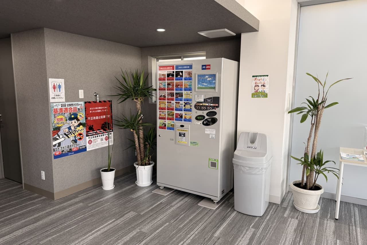 観葉植物が並ぶショールーム内の自動販売機設置スペース。