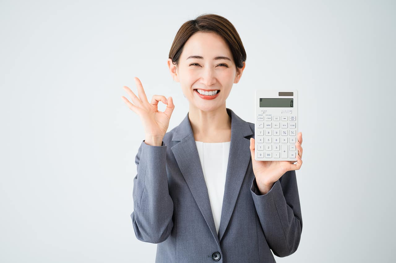 明るい笑顔で電卓を持っている女性スタッフ